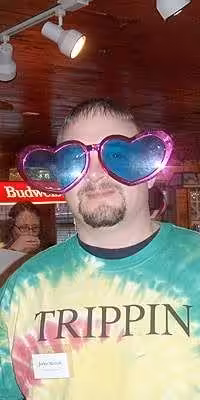 Someone in garish tie-dye clothing for A Karma Club murder mystery game